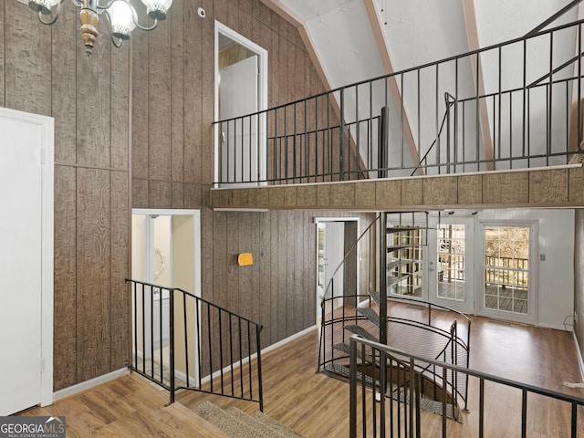 staircase with baseboards, a high ceiling, and wood finished floors