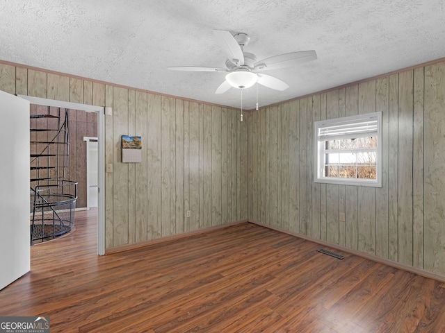 spare room featuring a textured ceiling, visible vents, and wood finished floors