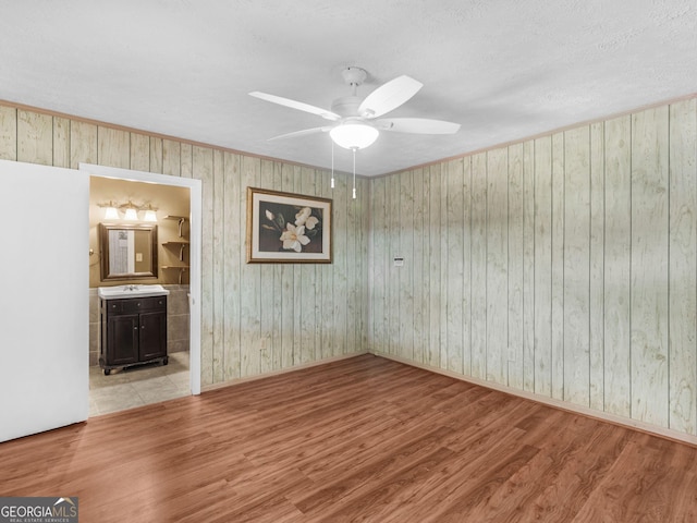 unfurnished room with wood finished floors and a ceiling fan