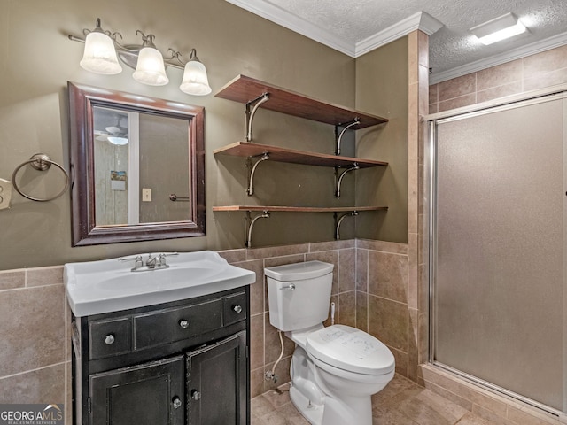 full bathroom with toilet, a textured ceiling, vanity, a shower stall, and tile walls