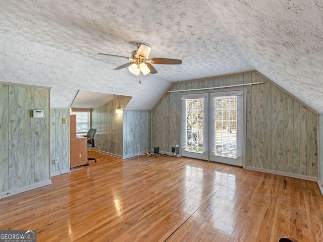 additional living space with lofted ceiling, hardwood / wood-style flooring, and baseboards