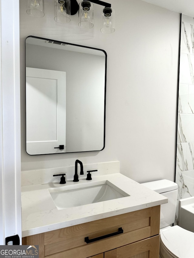 bathroom featuring vanity and toilet