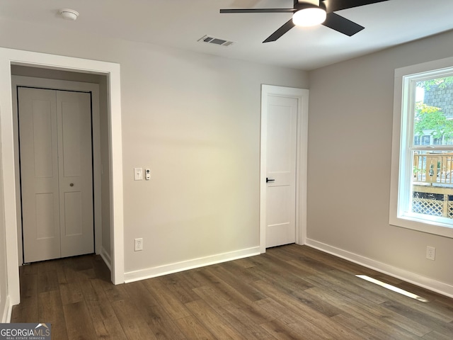 unfurnished bedroom featuring dark wood-type flooring, visible vents, and baseboards