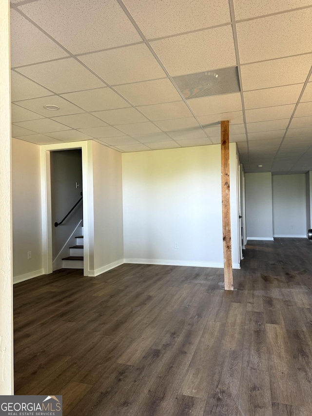 interior space featuring dark wood-style floors, a paneled ceiling, and baseboards