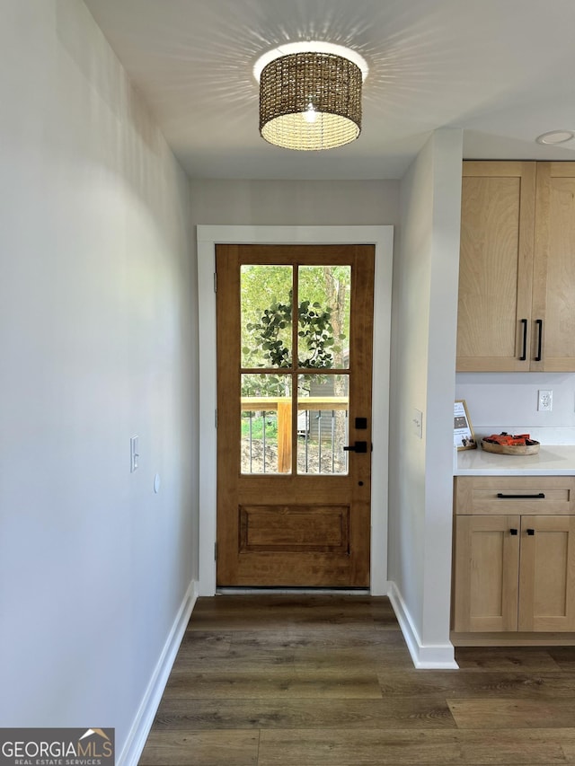 doorway to outside with dark wood-style floors and baseboards