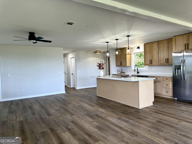 kitchen featuring a kitchen island, visible vents, open floor plan, and stainless steel fridge with ice dispenser