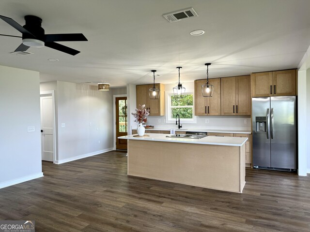 kitchen with a center island, dark wood-style flooring, stainless steel refrigerator with ice dispenser, light countertops, and visible vents