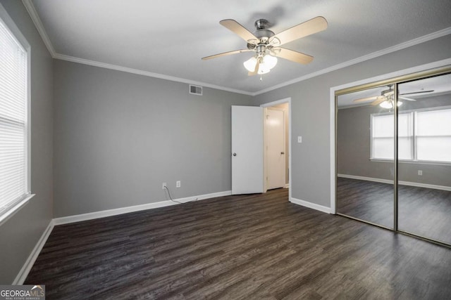 unfurnished bedroom with ornamental molding, wood finished floors, visible vents, and baseboards