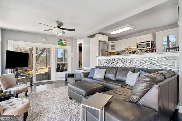 living area with dark wood-style floors and ceiling fan