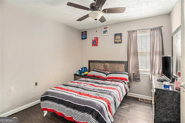 bedroom featuring a textured ceiling, wood finished floors, visible vents, and baseboards