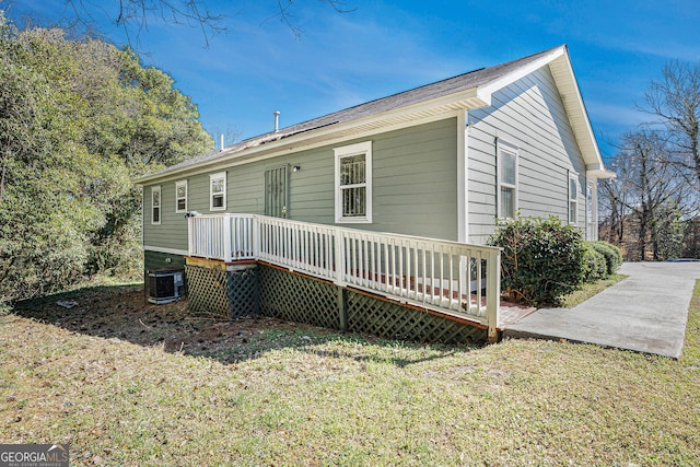 rear view of property featuring a lawn and a deck