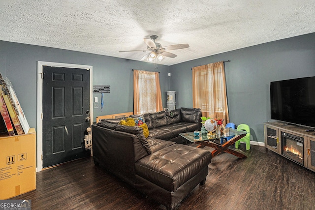 living area featuring a textured ceiling, wood finished floors, a ceiling fan, and baseboards