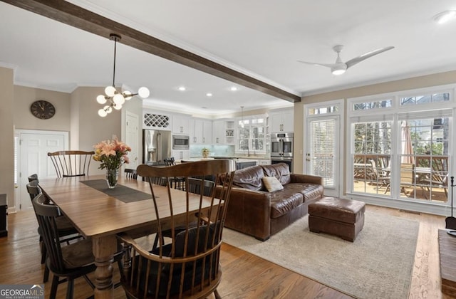 dining area with beamed ceiling, ornamental molding, ceiling fan with notable chandelier, dark wood finished floors, and recessed lighting