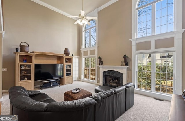 living area with visible vents, high vaulted ceiling, carpet, a premium fireplace, and ceiling fan