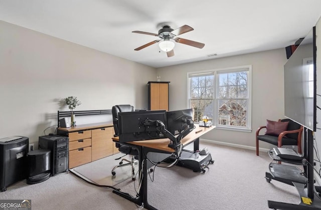 office space with light colored carpet, baseboards, and ceiling fan