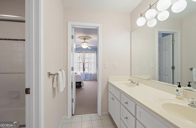 ensuite bathroom featuring double vanity, baseboards, tile patterned floors, and a sink