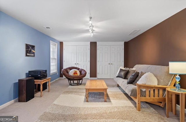 carpeted living area with baseboards and visible vents