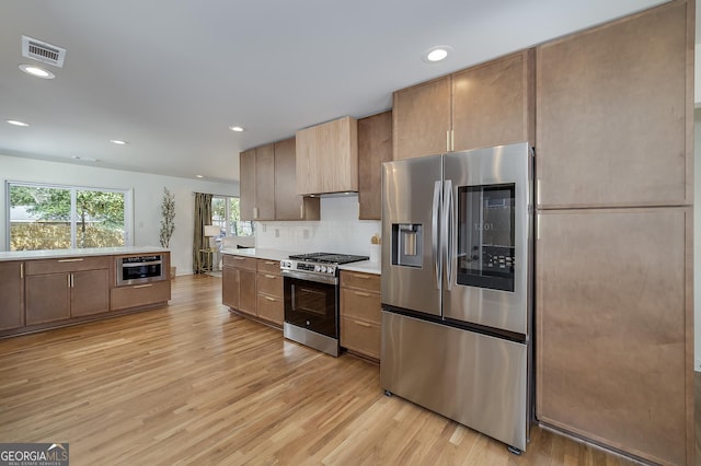 kitchen with light wood-type flooring, visible vents, appliances with stainless steel finishes, and light countertops