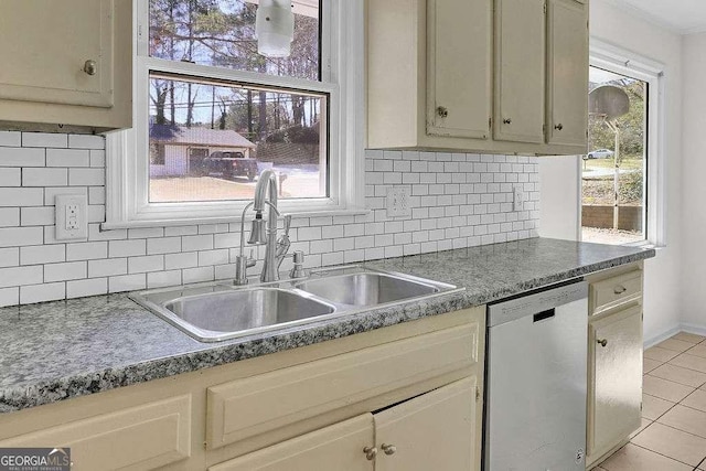 kitchen featuring decorative backsplash, dishwasher, dark countertops, a sink, and light tile patterned flooring