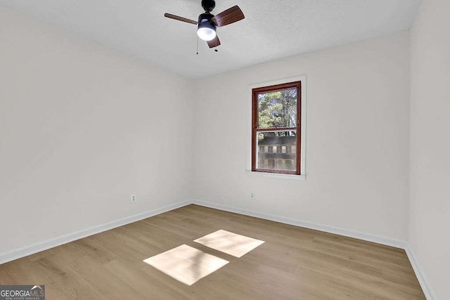 spare room featuring a ceiling fan, baseboards, and wood finished floors