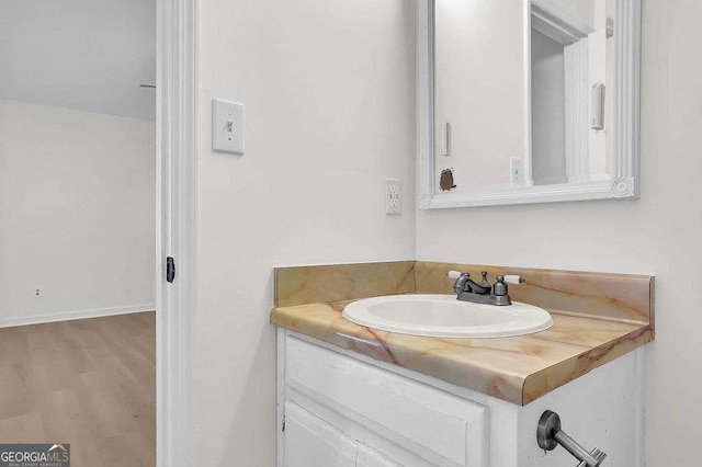 bathroom featuring vanity, baseboards, and wood finished floors