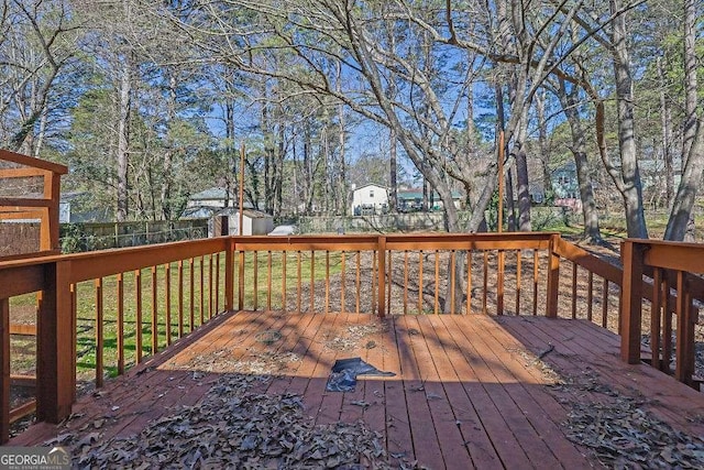 wooden deck with an outbuilding, a fenced backyard, and a shed