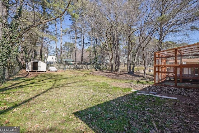 view of yard featuring an outbuilding, fence, and a storage unit