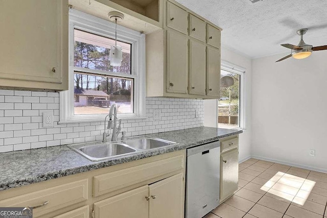 kitchen with decorative backsplash, dark countertops, a textured ceiling, stainless steel dishwasher, and a sink