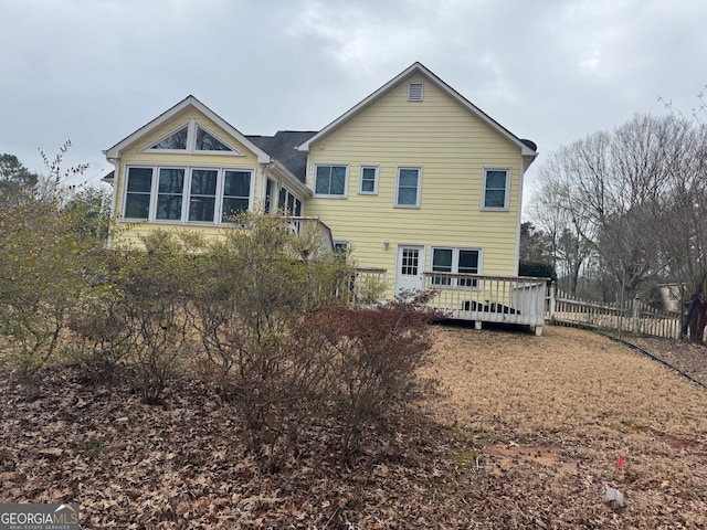 back of house featuring fence and a wooden deck