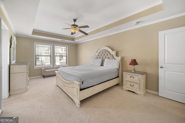 bedroom with ornamental molding, a raised ceiling, light colored carpet, and baseboards