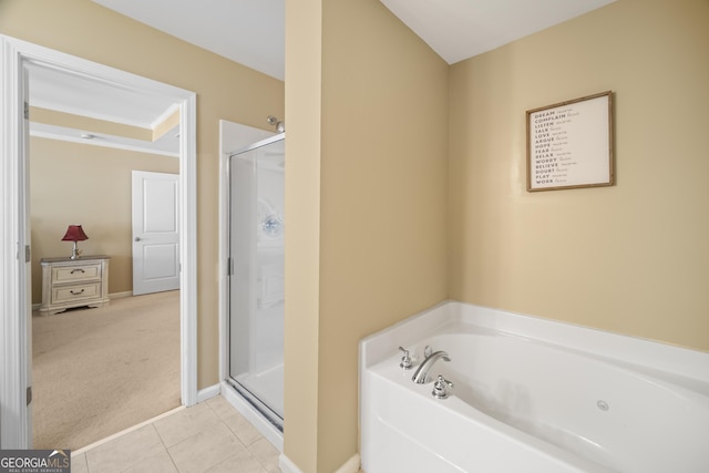 bathroom featuring a stall shower, a garden tub, baseboards, and tile patterned floors