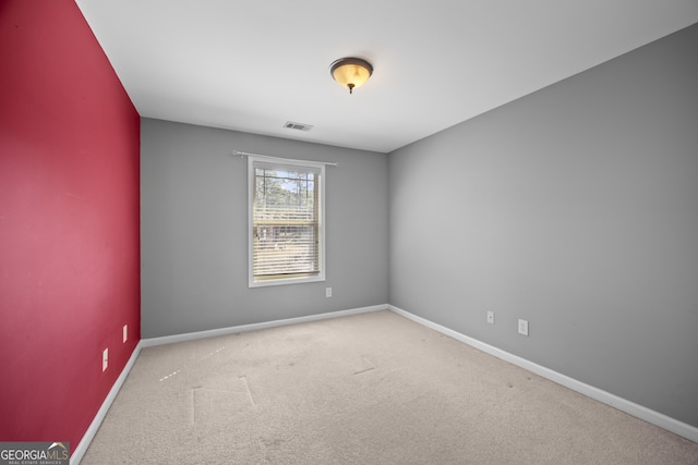 carpeted spare room with baseboards and visible vents