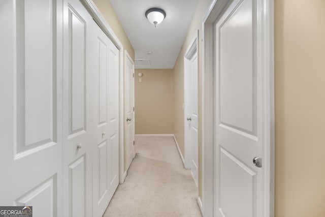 hall featuring light carpet and baseboards