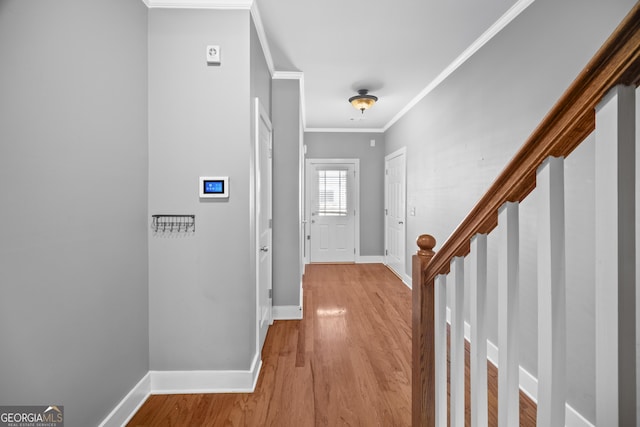 entrance foyer with wood finished floors, crown molding, baseboards, and stairs