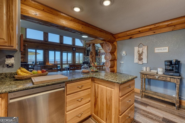 kitchen featuring beam ceiling, rustic walls, light wood-type flooring, dishwasher, and ornate columns