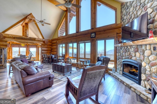 103 Wisteria Dr, Murphy, NC 28906 - living room featuring a ceiling fan, high vaulted ceiling, log walls, a fireplace, and wood finished floors