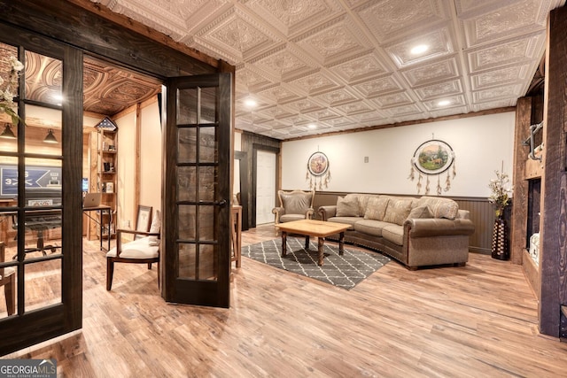 103 Wisteria Dr, Murphy, NC 28906 - living room featuring french doors, wood finished floors, a wainscoted wall, an ornate ceiling, and a large fireplace