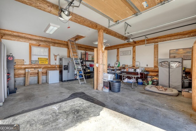 103 Wisteria Dr, Murphy, NC 28906 - garage featuring stainless steel refrigerator with ice dispenser, a workshop area, fridge, and a garage door opener