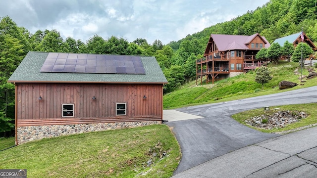 103 Wisteria Dr, Murphy, NC 28906 - view of home's exterior with solar panels, roof with shingles, a lawn, and a view of trees