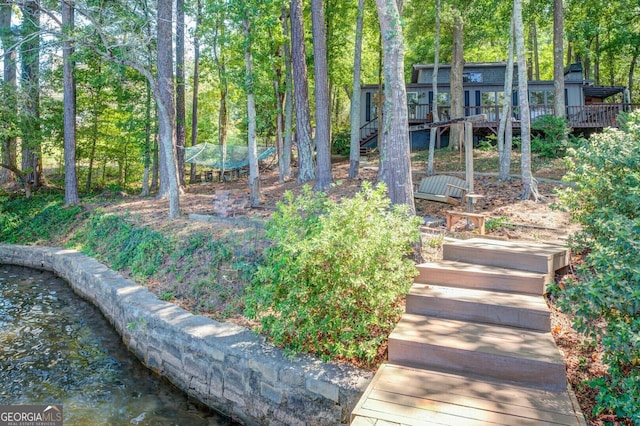 view of yard with a deck and stairs