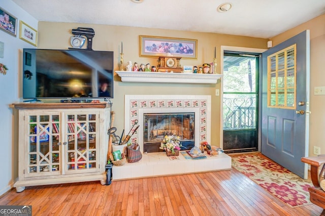 interior space with a tile fireplace and hardwood / wood-style floors