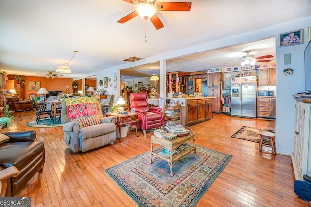 living room featuring light wood-type flooring and ceiling fan