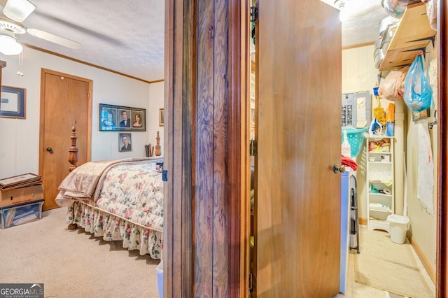 bedroom featuring a ceiling fan, carpet flooring, crown molding, and a textured ceiling