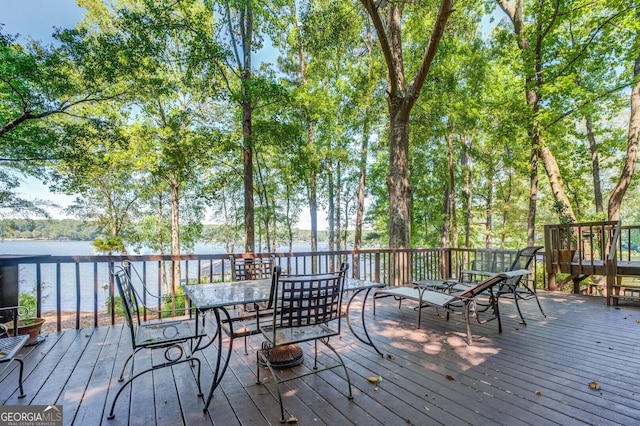 wooden deck featuring a water view and outdoor dining space