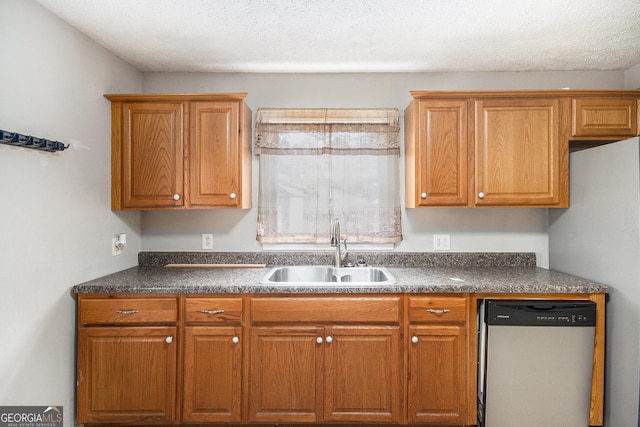 kitchen with dark countertops, dishwasher, brown cabinetry, and a sink