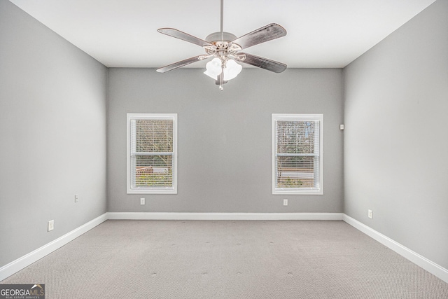 empty room featuring light carpet, a ceiling fan, and baseboards