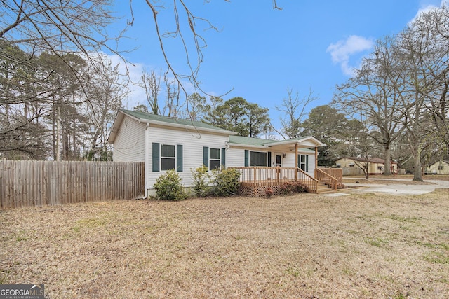 view of front of house with fence and a front lawn