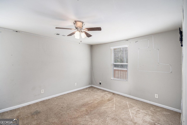 carpeted empty room featuring a ceiling fan, visible vents, and baseboards