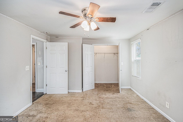 unfurnished bedroom with a ceiling fan, carpet, visible vents, and baseboards