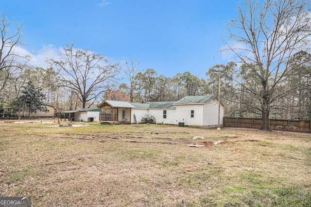 back of house with crawl space, central AC unit, a lawn, and fence